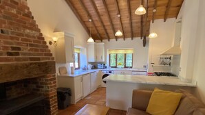 Un área de estar acogedora con chimenea, un sofá y una mesa de madera.