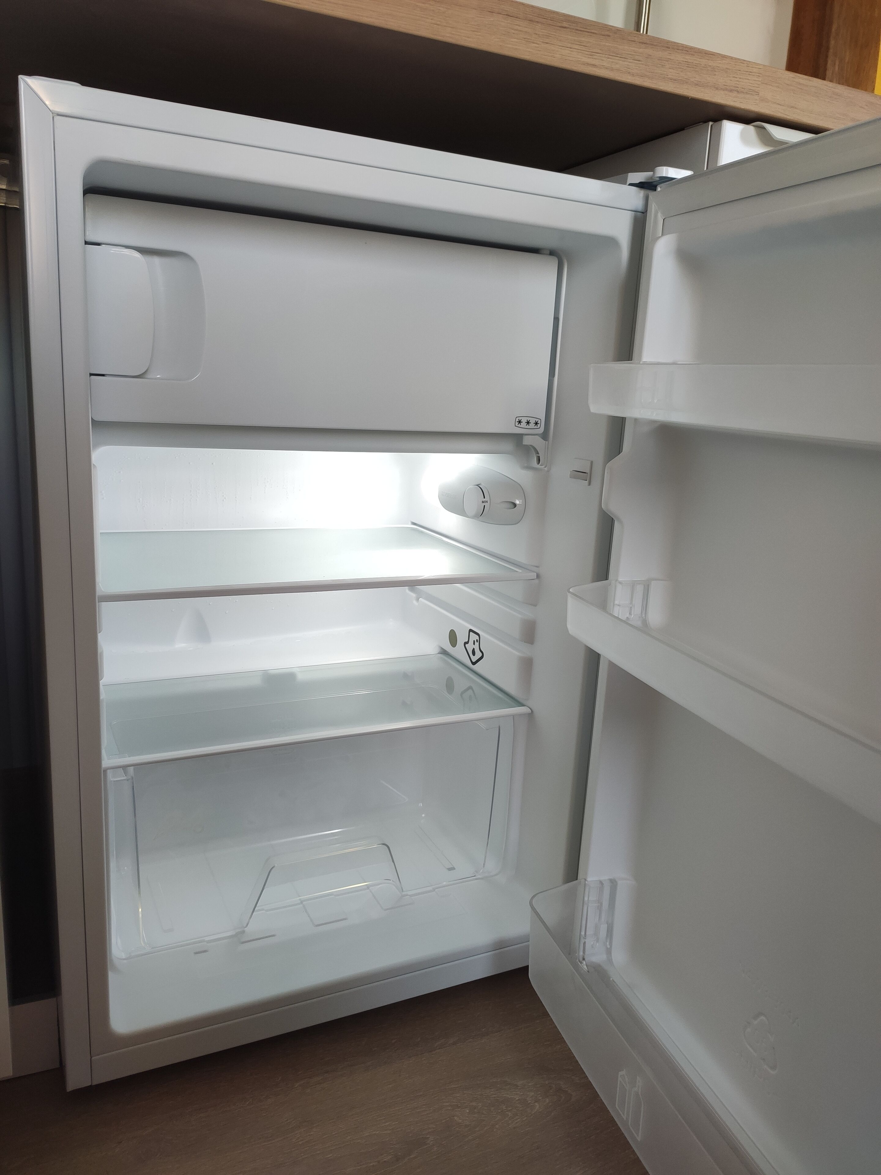 An open refrigerator with multiple shelves and a freezer compartment.