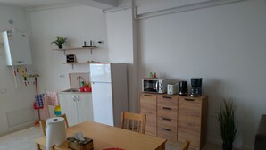 A compact kitchen with a refrigerator, microwave, toaster, and coffee maker. There is a dining table with chairs and a small potted plant. - 2 apartments, of 2 rooms each, next each other, for max 10 persons, beachfront (Navodari)