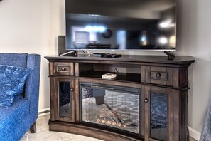 A dark wooden entertainment center with a flat-screen TV mounted above it.