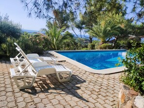 A swimming pool with lounge chairs and a view of the sea. - Villa vue Mer, Piscine et Jacuzzi, 15 min de la Plage et du Village (La Croix-Valmer)