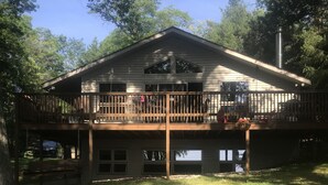 A two-story house with a balcony, a garage, and a well-maintained lawn. - Lake front beauty (Hillman)