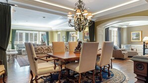 A spacious dining room with a large wooden table and matching chairs, a chandelier, and a patterned rug. - Charlie's Slopeside: Luxury Ski-In/Out, BC Village, Sleeps 8, 3 King Beds, AC, Walk to Everything (Beaver Creek)
