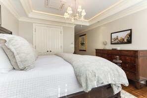 A bedroom with a large bed, a wooden dresser, a chandelier, and a framed picture on the wall. - Charlie's Slopeside: Luxury Ski-In/Out, BC Village, Sleeps 8, 3 King Beds, AC, Walk to Everything (Beaver Creek)