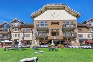 A multi-story hotel with a central clock, outdoor seating, and flower arrangements. - Ski-in/out 4BR Beaver Creek condo with mountain views. (Beaver Creek)