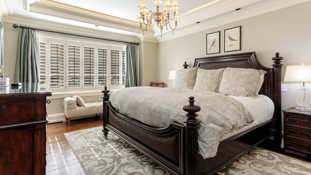 A bedroom with a large bed, a dresser, a chair, a nightstand, and a chandelier. - Charlie's Slopeside: Luxury Ski-In/Out, BC Village, Sleeps 8, 3 King Beds, AC, Walk to Everything (Beaver Creek)