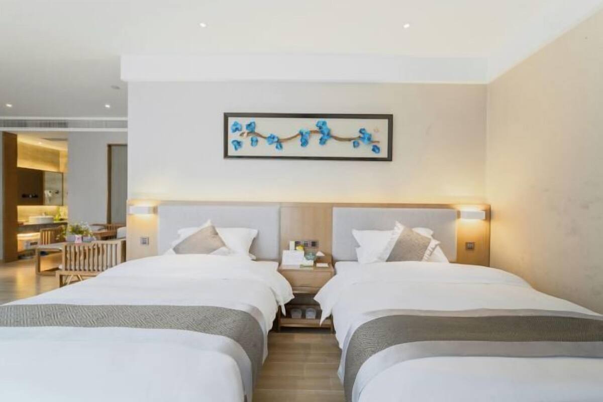A hotel room with two beds, a modern design, and a framed artwork on the wall.