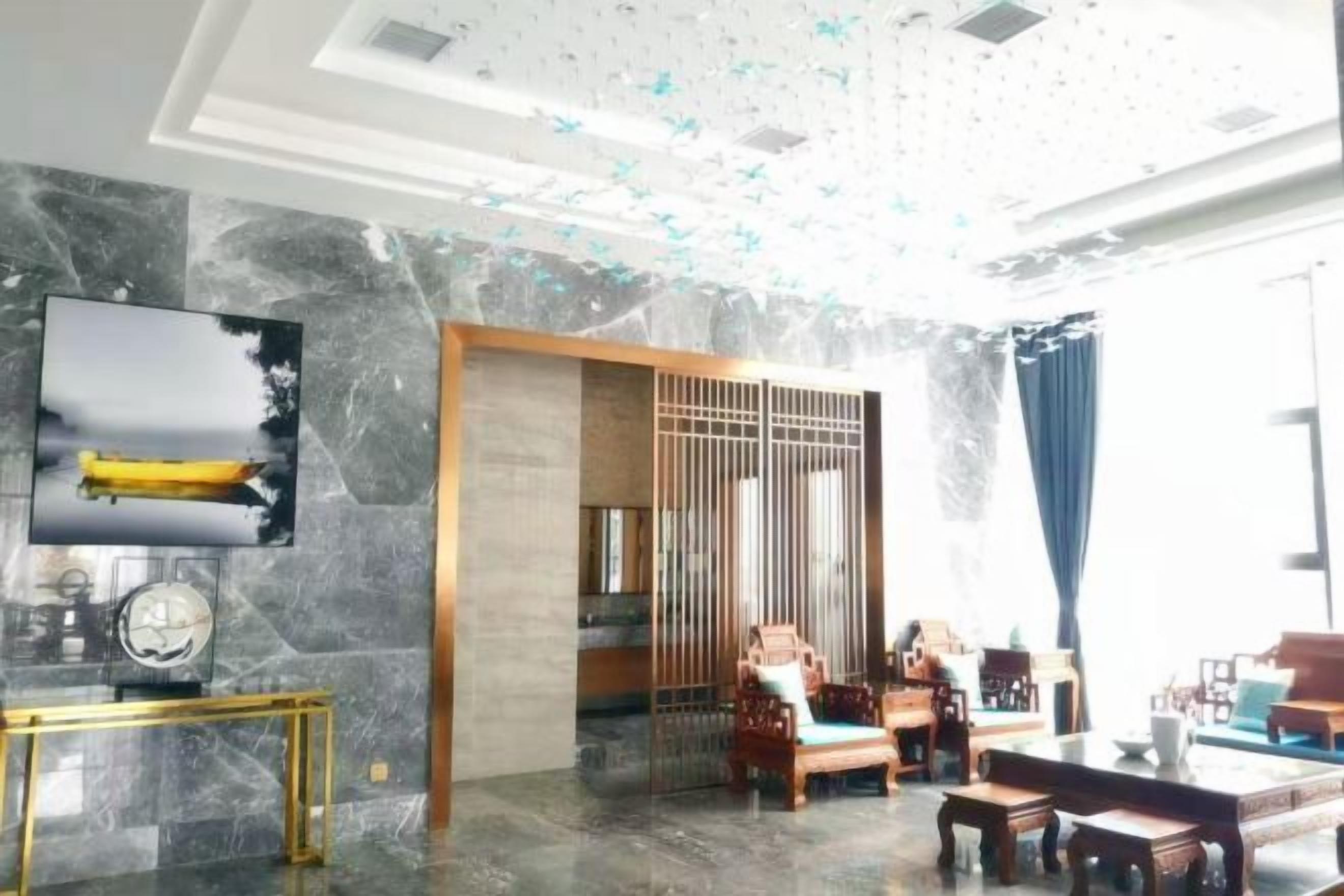 A modern interior with a seating area, a television, and a decorative ceiling.