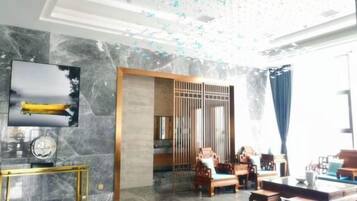 A modern interior with a seating area, a television, and a decorative ceiling.