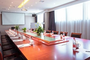 A conference room with a long table, chairs, a projector screen, and a large window. - Xingzhike Hotel (Wuchuan)