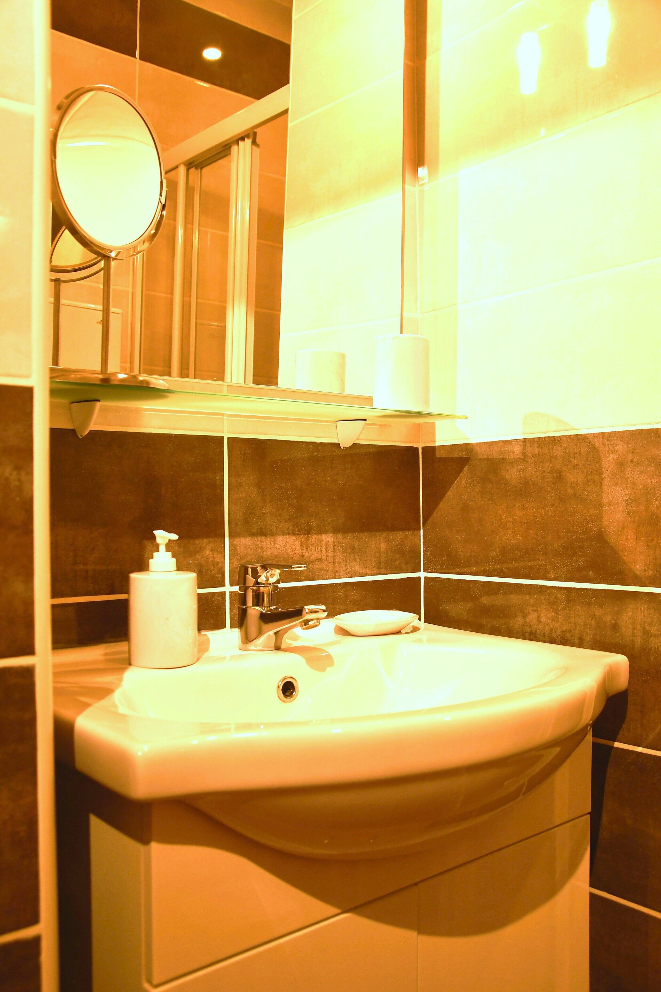 Ein Badezimmer mit Waschbecken, Spiegel und Pflegeprodukten.