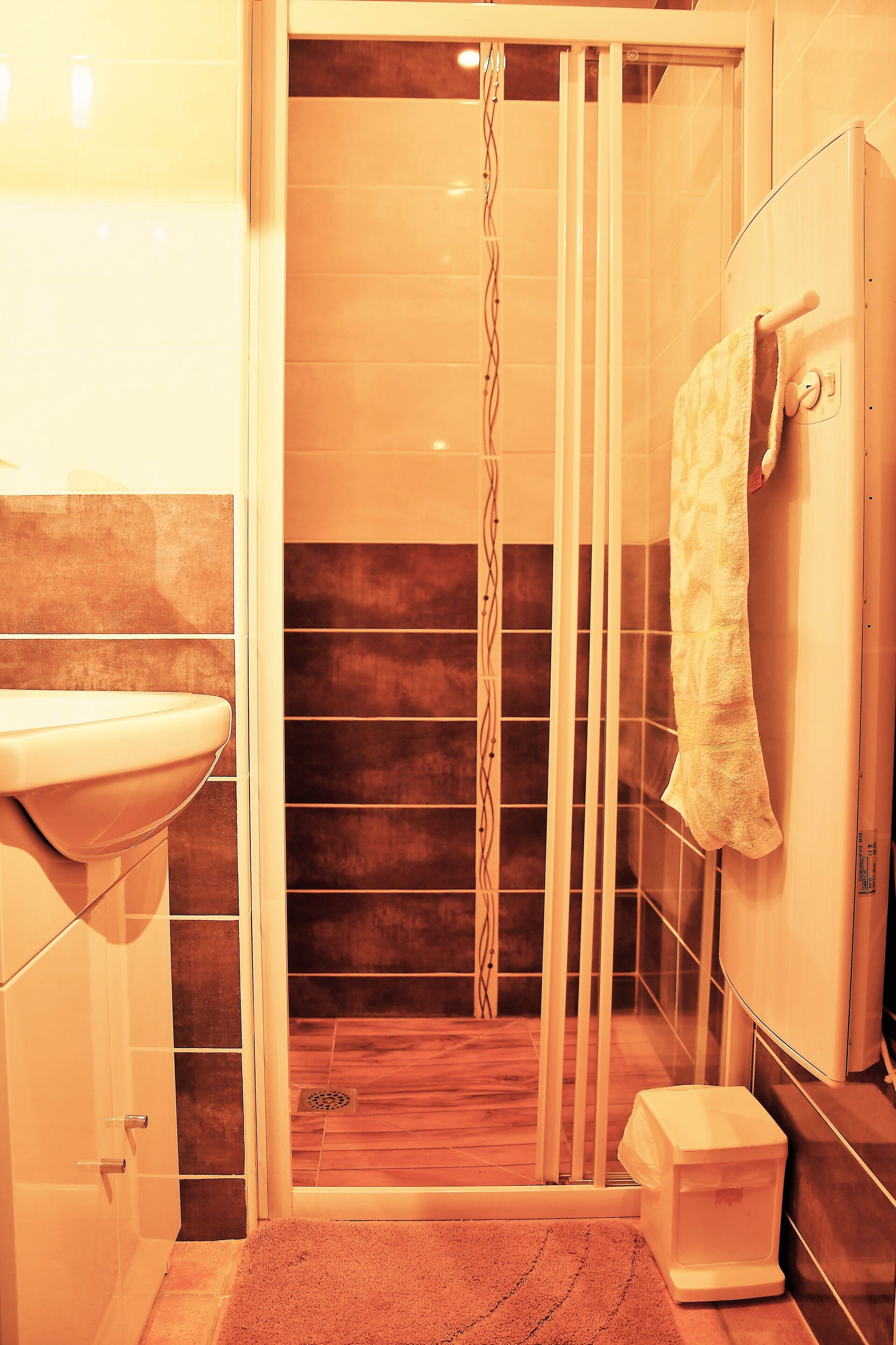 Une salle de bain équipée d’un lavabo, d’une douche et d’un porte-serviettes.