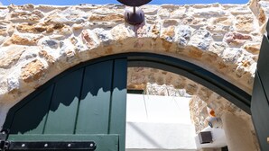 Un bâtiment en pierre avec une porte verte et une cloche.
