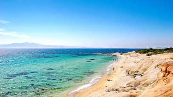 Ranta lähistöllä, aurinkotuoleja, rantapyyhkeitä