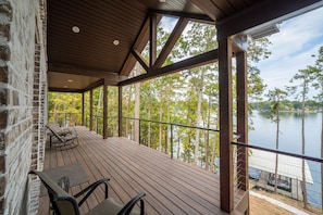 Um deck de madeira com vista para um lago e árvores.