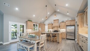 Une cuisine spacieuse avec des meubles en bois, un îlot central et un grand réfrigérateur.
