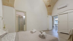Ein Hotelzimmer mit Bett, Schreibtisch, Dusche und Kleiderschrank.