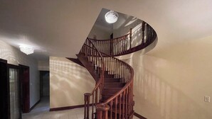 Eine Wendeltreppe mit Holzwerteln und einem Chandelier.