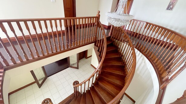 Eine hölzerne Wendeltreppe mit einem Chandelier.