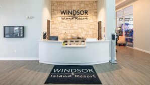 A reception area with a stone wall, a reception desk, and a welcome mat.
