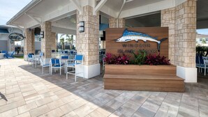 A hotel entrance with a sign reading "Windsor Island Resort" and a large wooden planter with plants.