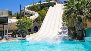 Tobogan d'aigües a un parc temàtic amb una piscina a la base.