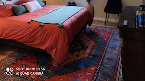 A bedroom with a bed, a window, a desk, and a chair. - Chambre vue sur le Jardin (Rivière)