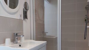 A bathroom with a sink, mirror, and shower. - Chambre vue sur le Jardin (Rivière)