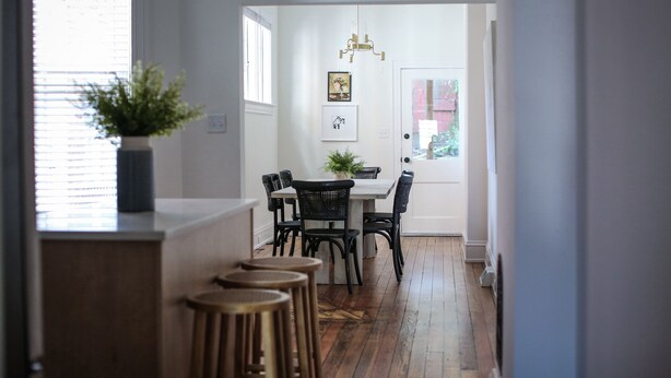 A dining area with a white table, black chairs, and a potted plant. - Beautiful 4bd, 2.5ba Lancaster Center City Townhome (Lancaster)