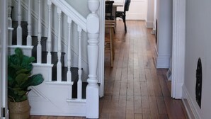 A hallway with a white staircase leading to a dining area. - Beautiful 4bd, 2.5ba Lancaster Center City Townhome (Lancaster)