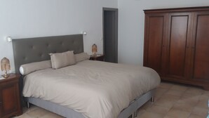 A bedroom with a bed, nightstands, a wardrobe, and a door. - Villa near beach, golf course, verdon gorges (Trans-en-Provence)