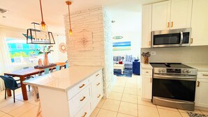 A modern kitchen with white cabinets, a built-in microwave, and a stainless steel oven. - Casa Azul, Key Largo, Home w Private Pool & Dock (Key Largo)