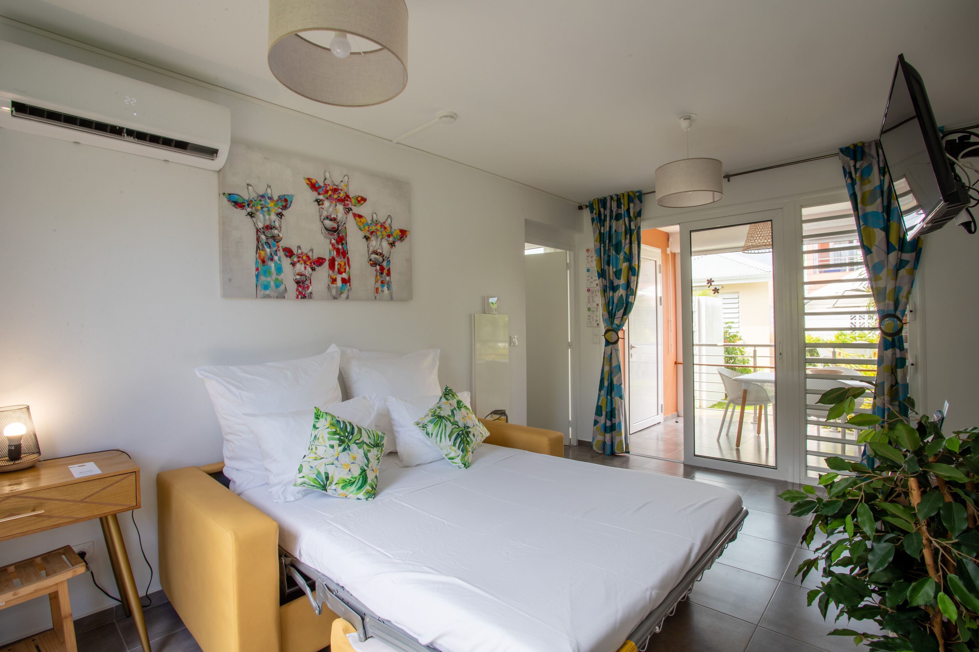 Une chambre à coucher avec un lit, une table de chevet et une fenêtre avec des rideaux.
