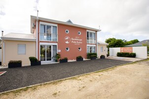 Um hotel com uma grande placa com a inscrição 'Hôtel Guadaloup Palm Suites'.
