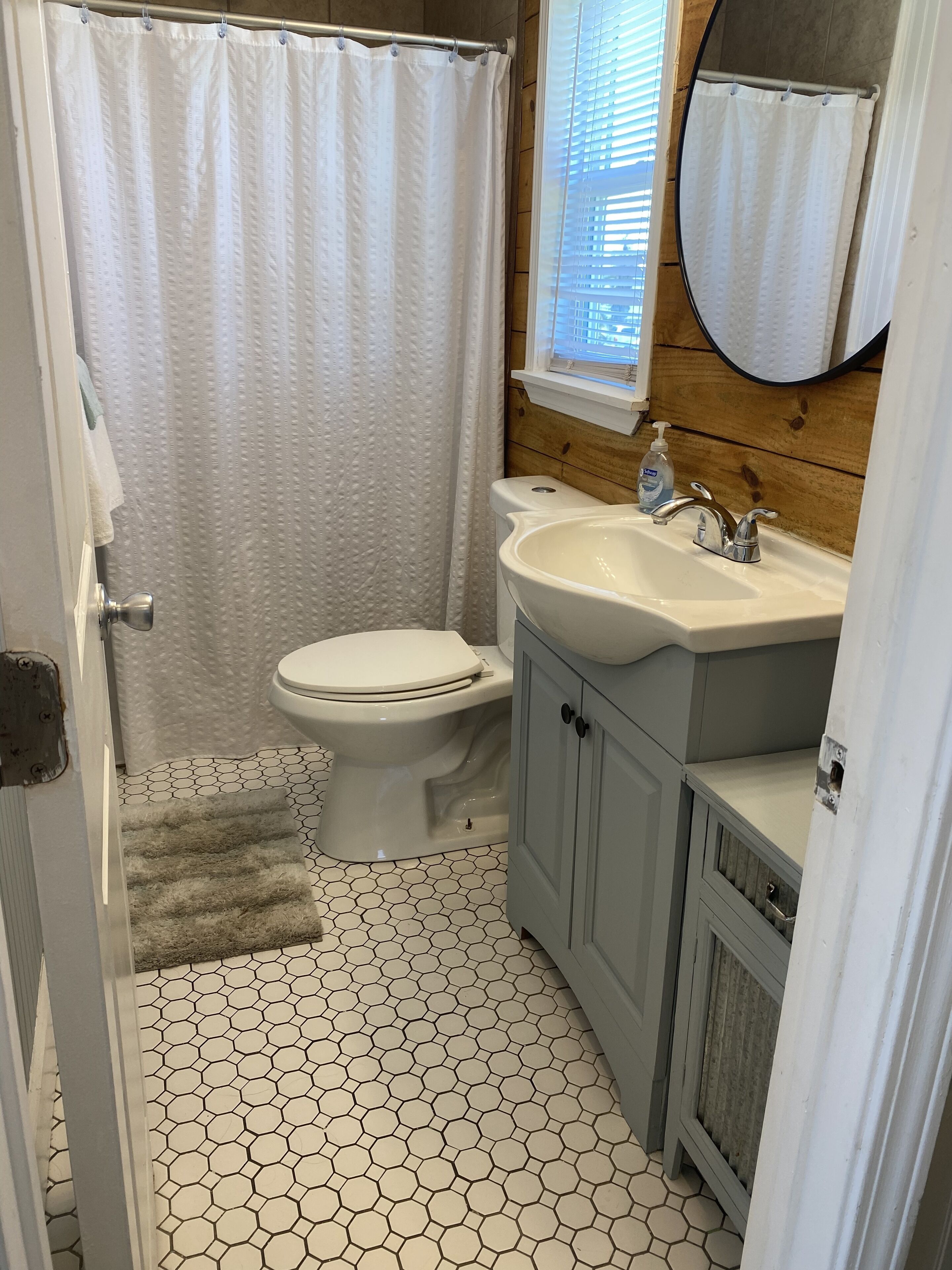 Une salle de bain équipée de toilettes, d’un lavabo et d’un rideau de douche.