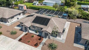 Ein Wohngebiet mit mehreren Häusern, Solaranlagen und einem gepflegten Garten.