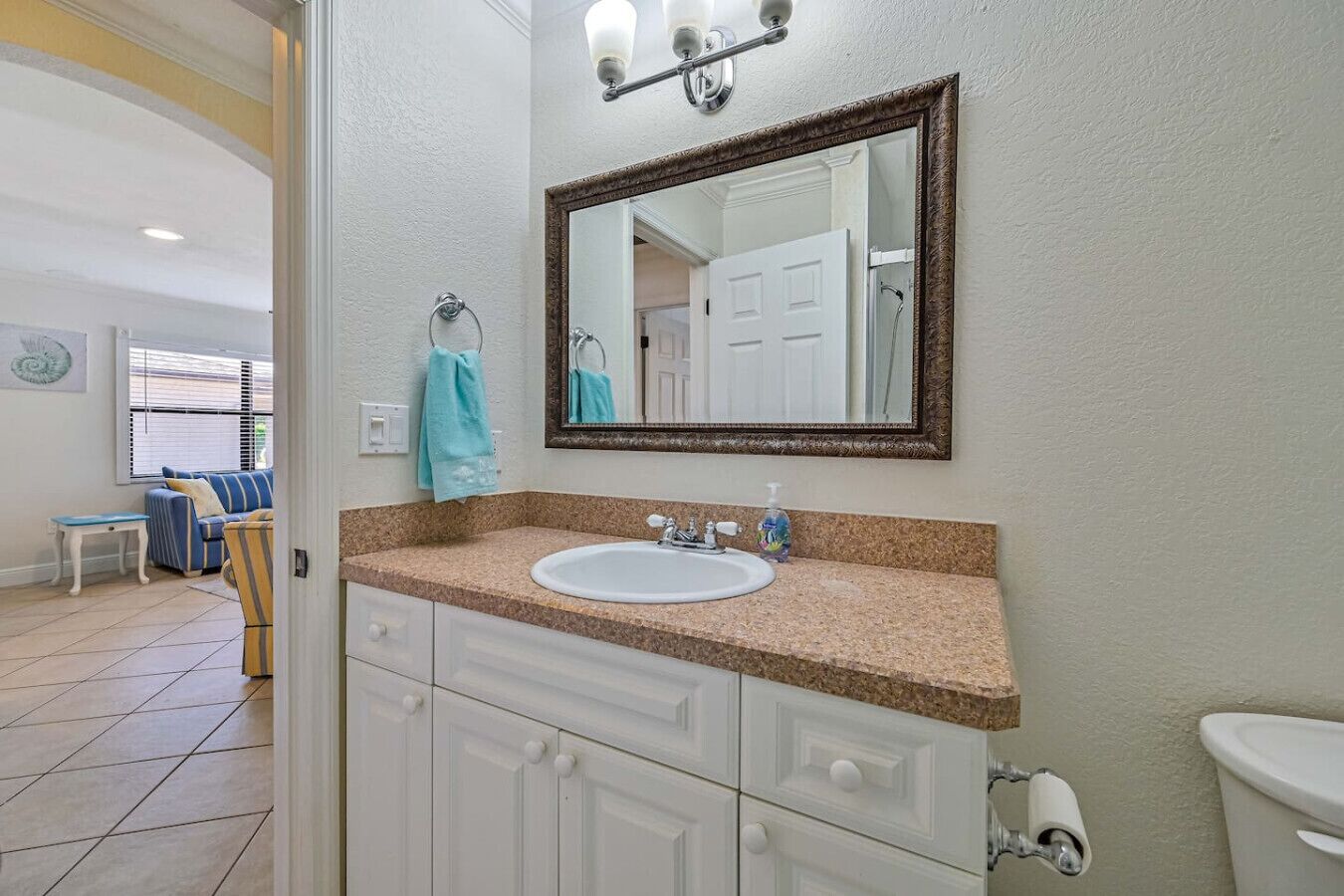 Un bagno con un lavandino bianco, uno specchio e un water.
