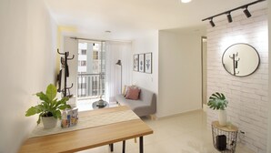 Una sala de estar moderna con un sofá, una mesa de comedor y una planta en maceta.
