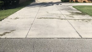 Ein zweistöckiges Haus mit Garage, Auffahrt und Rasen.