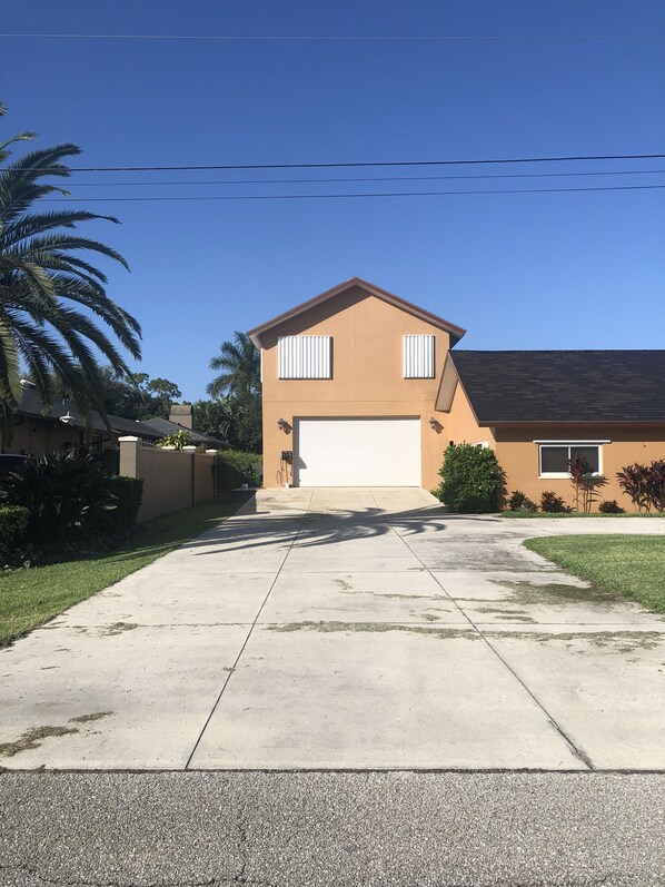 Ein zweistöckiges Haus mit Garage, Auffahrt und Rasen.