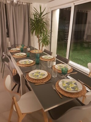 Enjoy meals in this dining area with a long table, comfortable chairs, and a beautiful view.