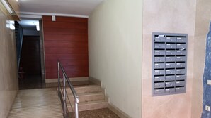 A staircase with a metal railing leading to a landing with a mail slot. - ATIC, PRIVATE TERRACE, 2 BEDROOMS (Barcelona)