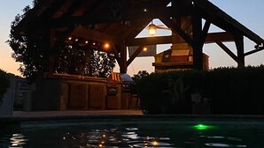 Un bâtiment doté d’un vaste patio ouvert, d’une piscine agrémentée de bougies flottantes et d’un ciel dégagé.