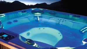 Un bain à remous doté d’un panneau de commande et d’une terrasse en bois.