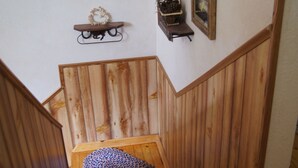 Una escalera de madera con un pequeño tapete en la parte inferior.