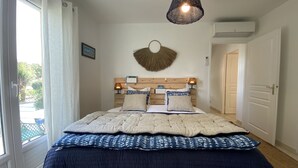 Een slaapkamer met een bed, een wandlamp, een fotolijst en een deur.