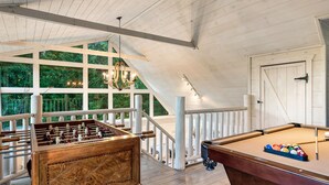 A wooden-floored room with a foosball table, pool table, and large windows overlooking greenery. - Hot tub cabin near Pigeon Forge, game room, mountain views (Sevierville)