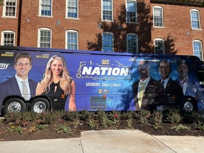 A bus with a large advertisement for SEC Nation, featuring several individuals.