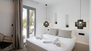 Une chambre d’hôtel moderne avec un grand lit, deux lampes fixées au mur, une petite plante en pot et une vue à travers la porte vitrée.