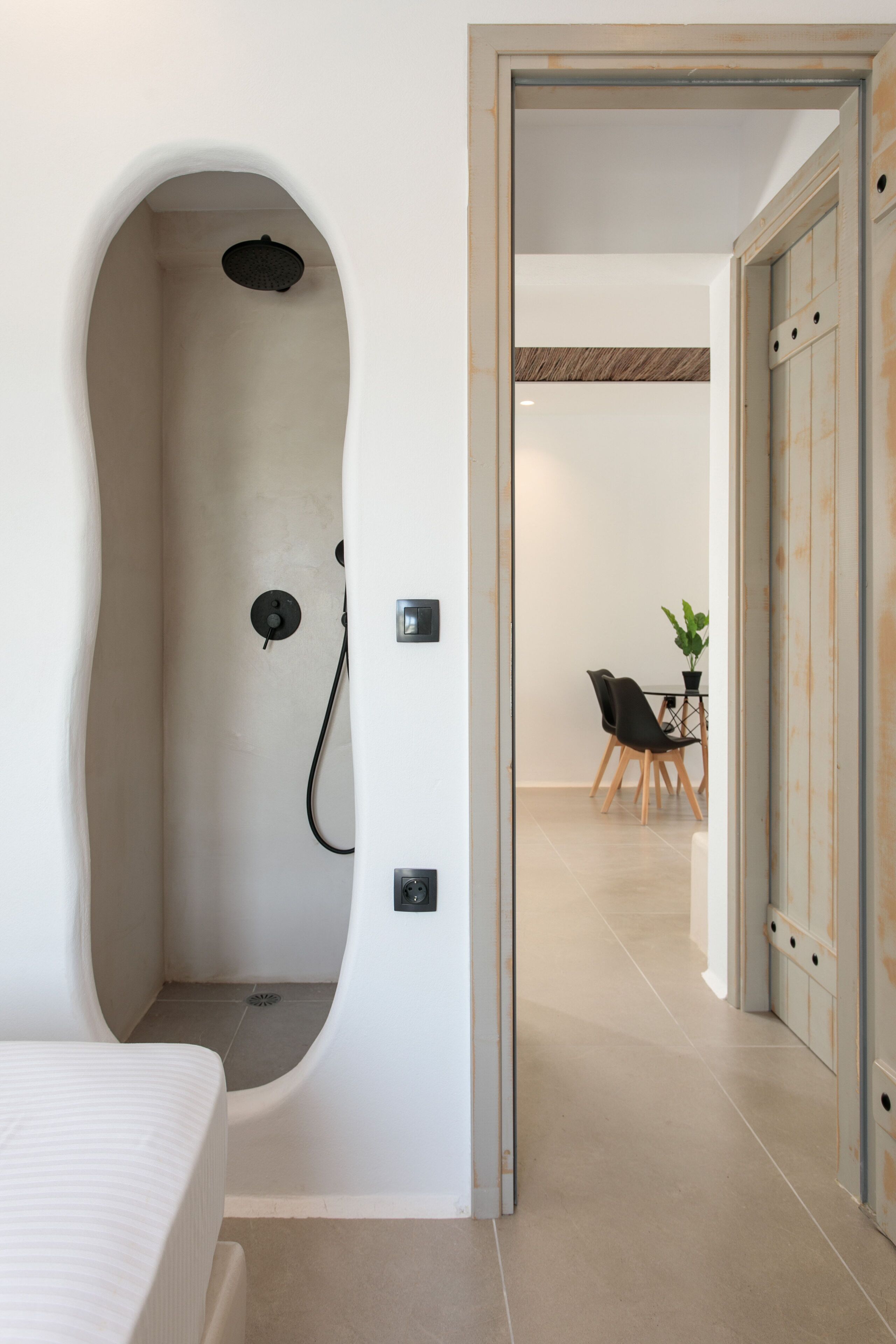 A modern bathroom with a unique bathtub design, a shower, and a visible toilet.